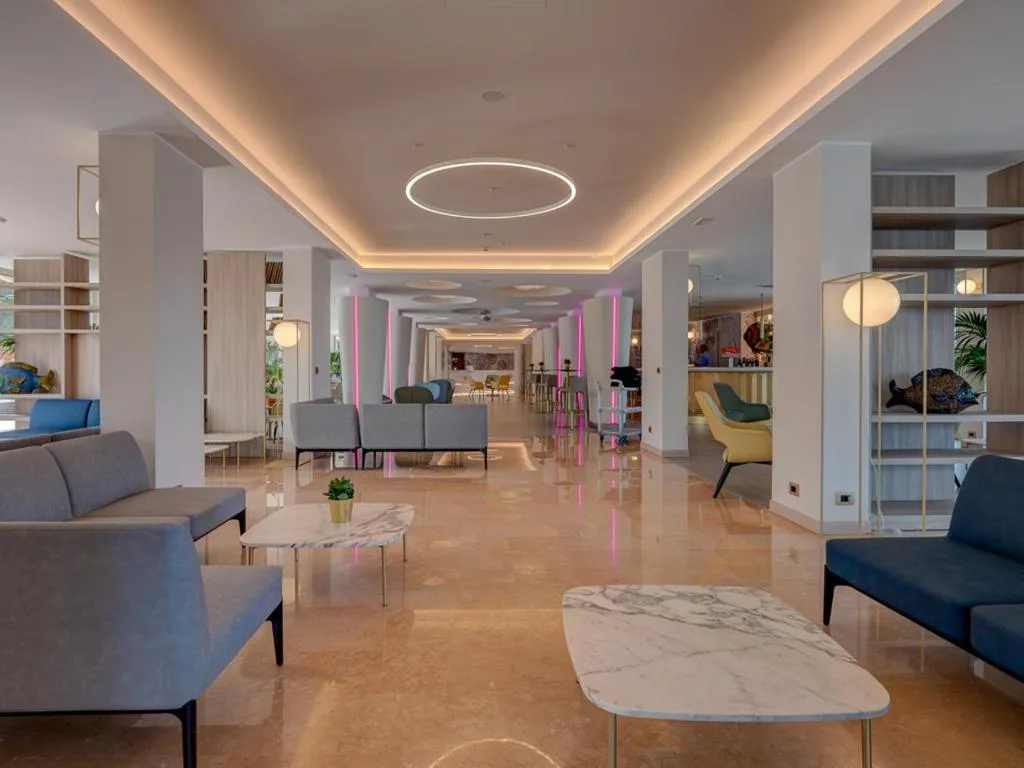 Ampia hall moderna con divani, tavolini in marmo e illuminazione di design