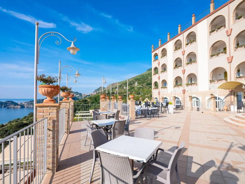 Terrazza dell'hotel con tavoli e vista sul mare e sulla costa