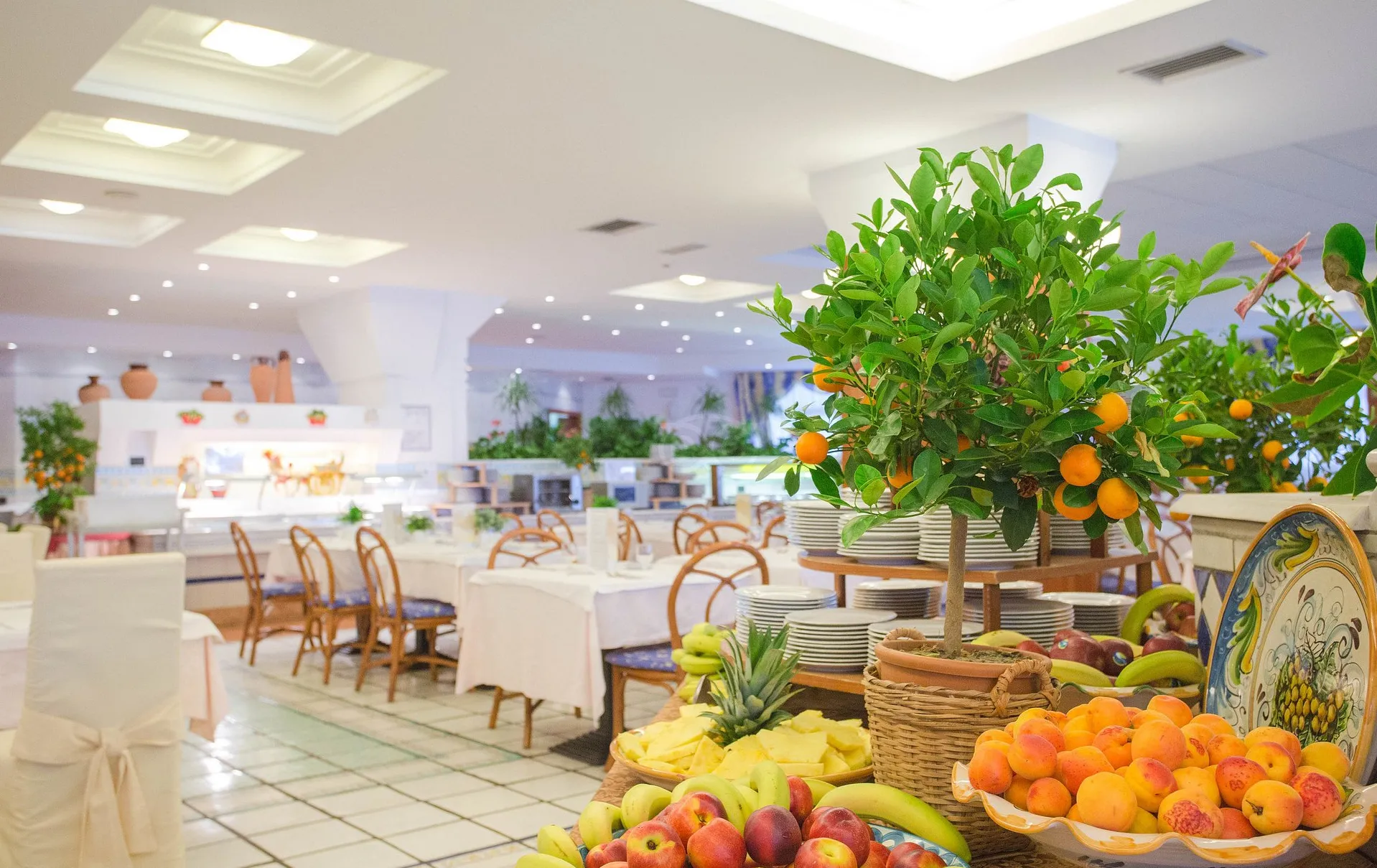 Sala ristorante interna con buffet di frutta fresca e tavoli apparecchiati