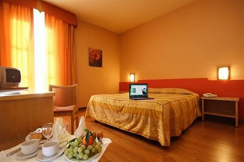 Camera con letto matrimoniale, copriletto dorato e colazione servita in primo piano