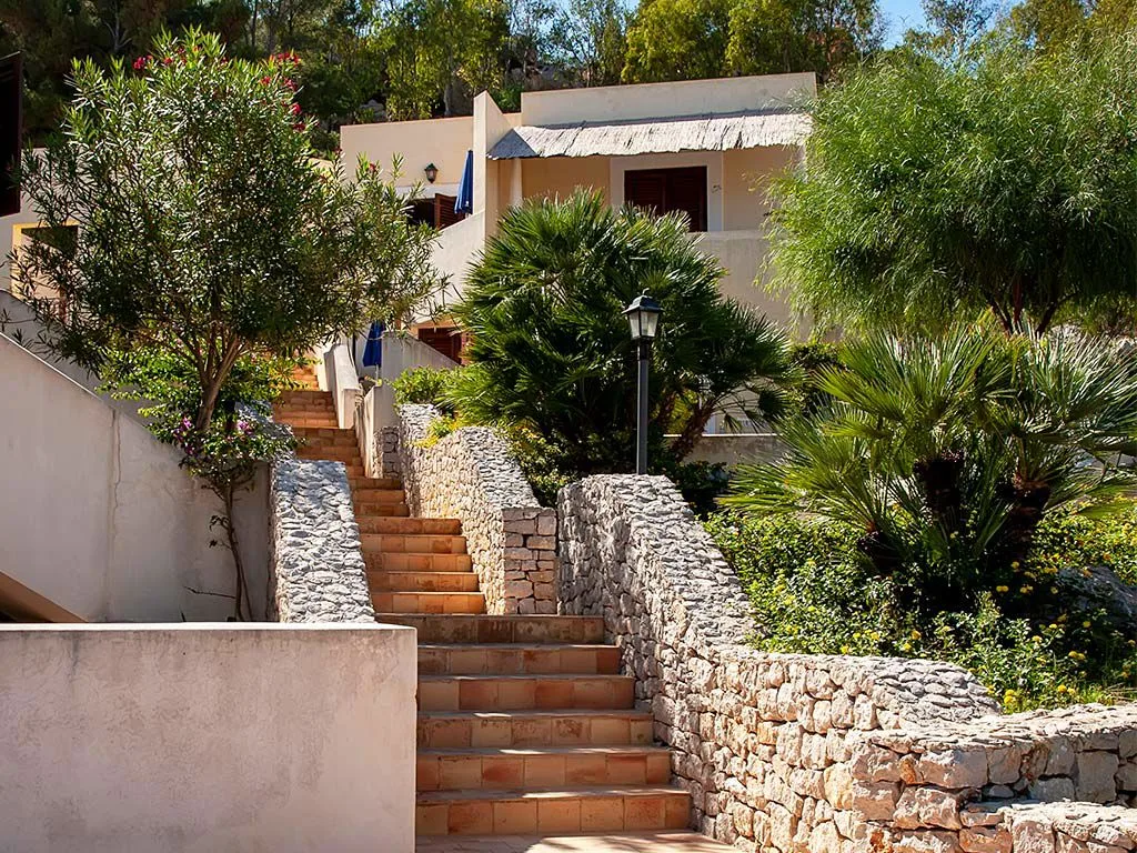 Scala in pietra immersa nel giardino mediterraneo del resort