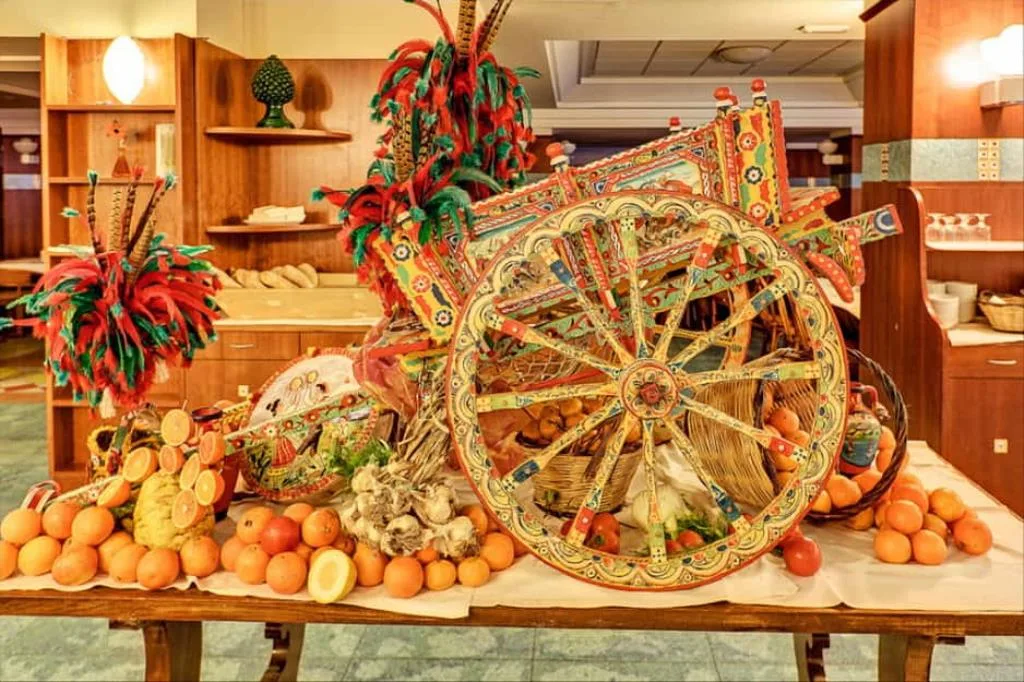 Tipico carretto siciliano decorato con frutta fresca e arance esposto nella sala buffet