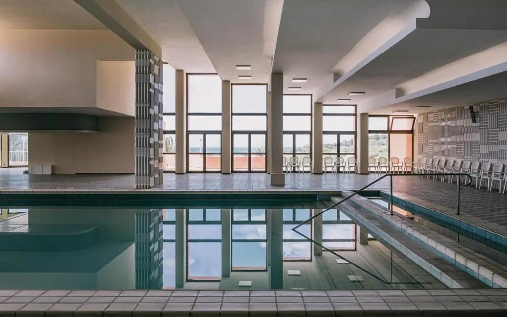 Piscina coperta interna con ampie vetrate e vista sul mare