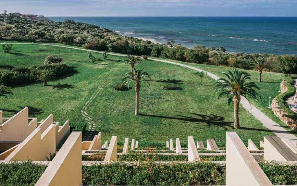 Ampio giardino con palme e prato verde affacciato sul mare