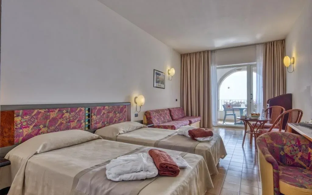 Camera con letti separati, divano e balcone con vista