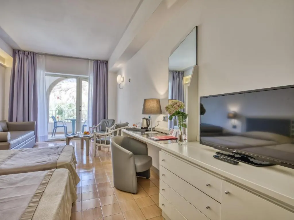 Camera moderna con TV, scrivania e balcone