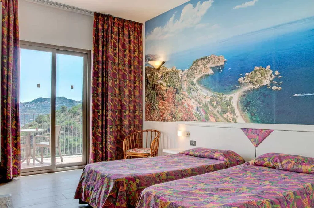 Camera con due letti e murale panoramico della costa siciliana