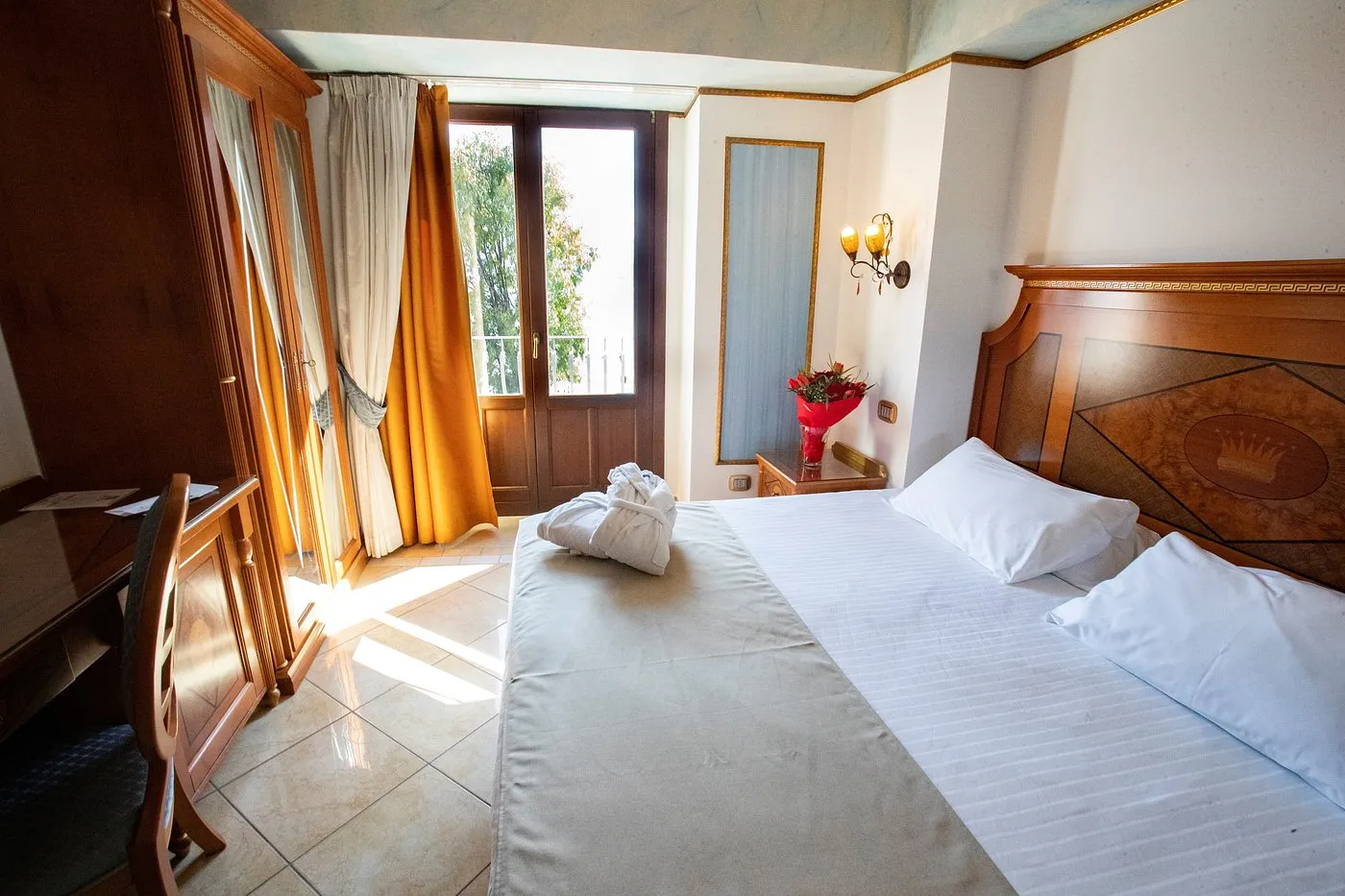Camera luminosa con letto matrimoniale, porta finestra e balcone
