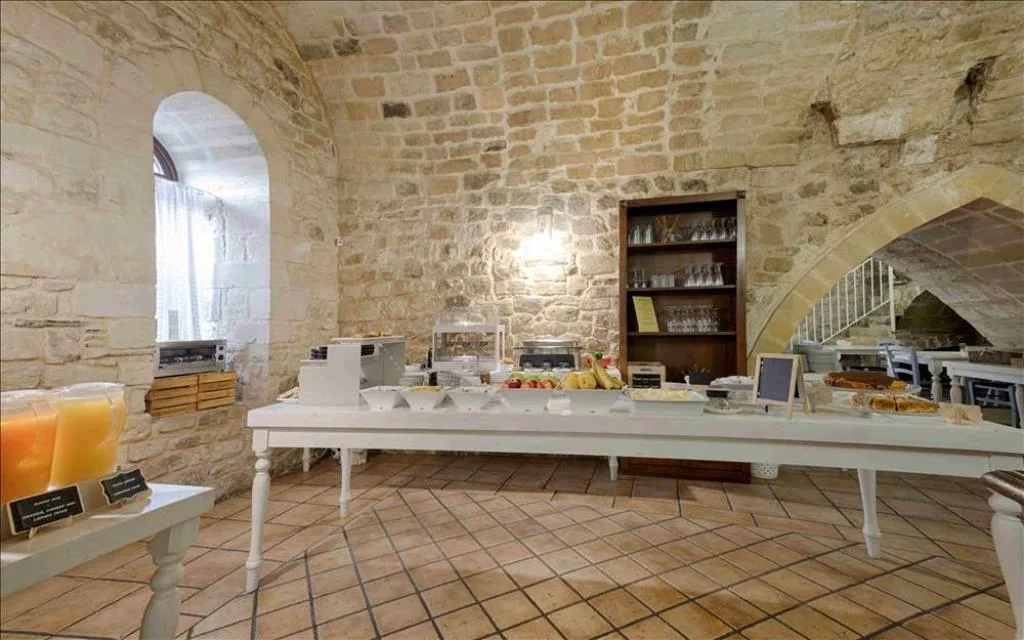 Sala colazione a buffet con pareti in pietra, succhi e prodotti freschi