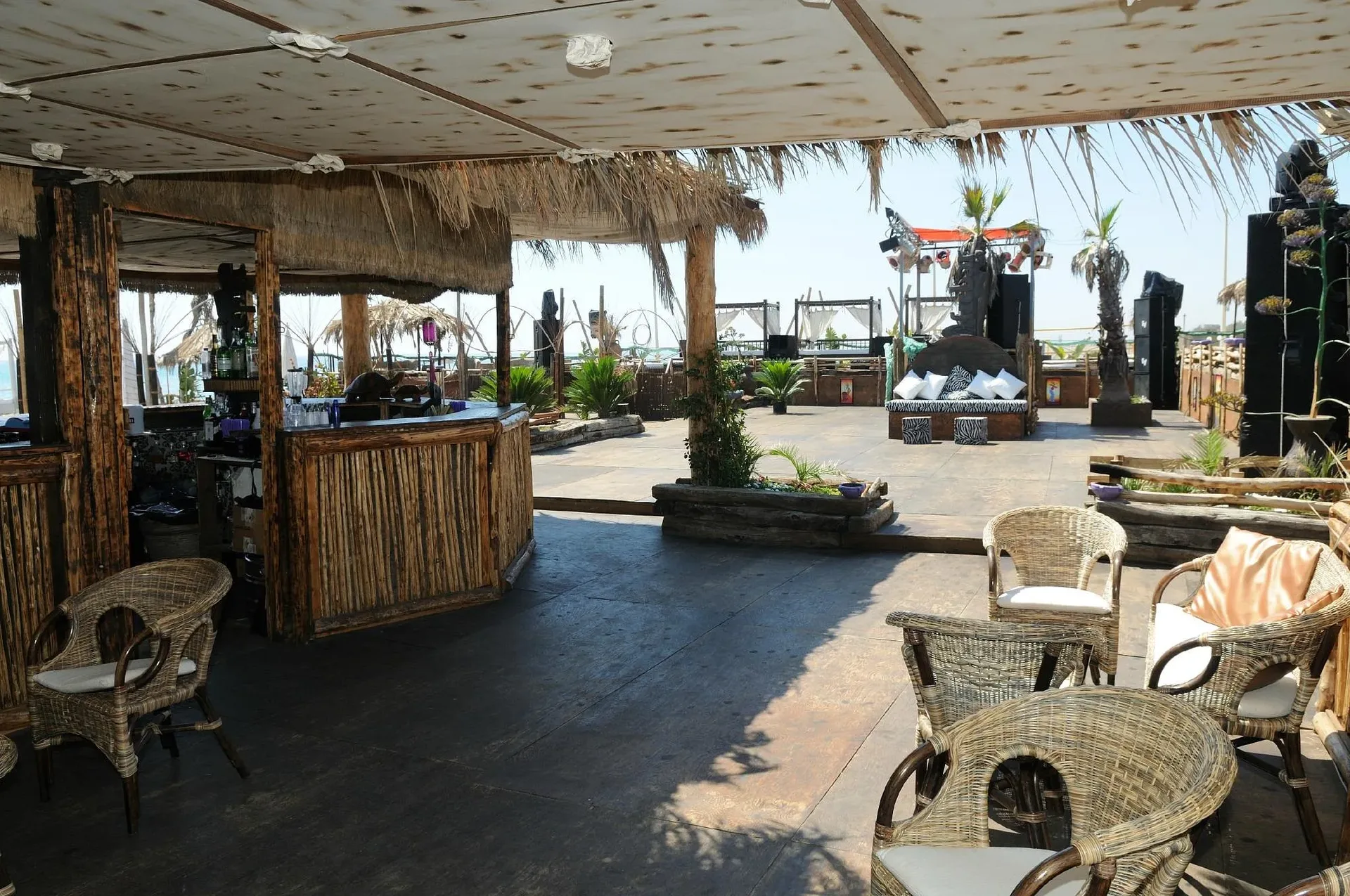 Interno di beach bar con arredi in bambù e tetto in paglia vista mare
