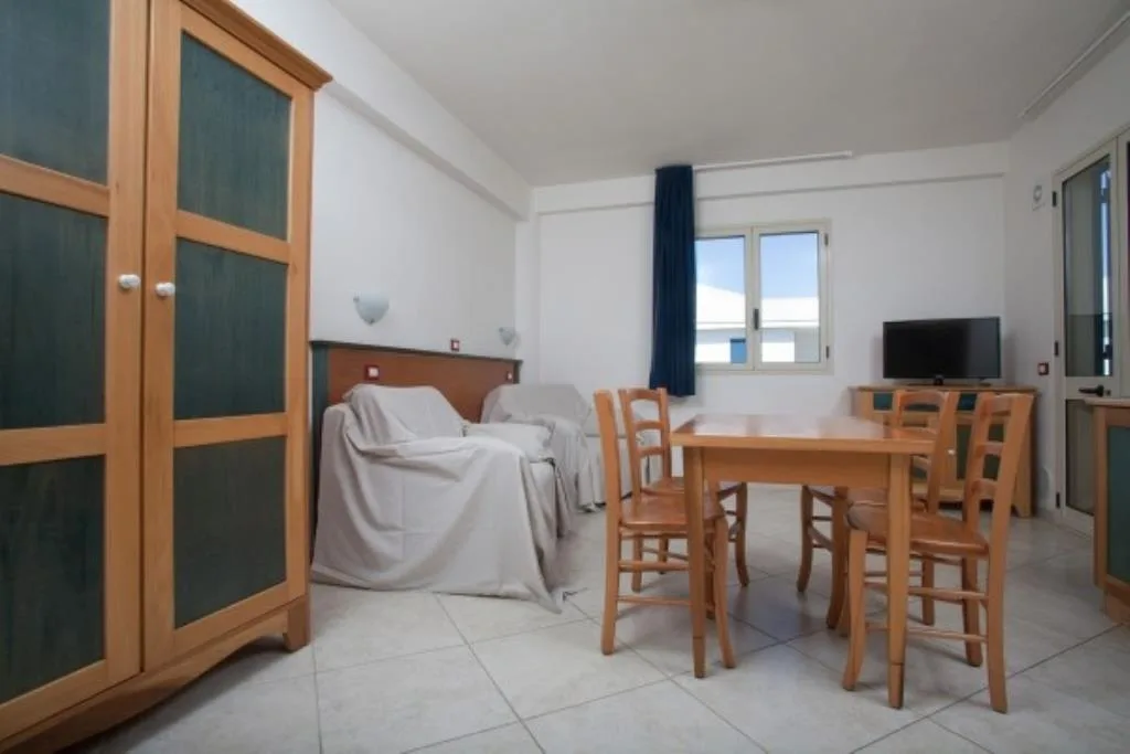 Soggiorno con divano, tavolo da pranzo e armadio in legno