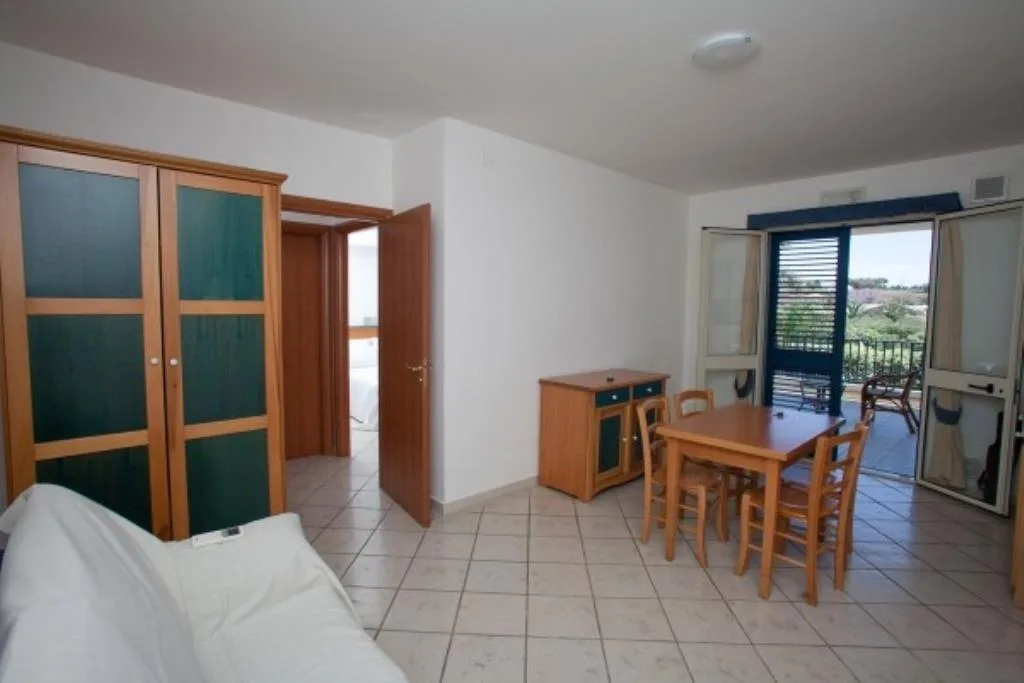 Soggiorno luminoso con tavolo da pranzo e accesso al balcone