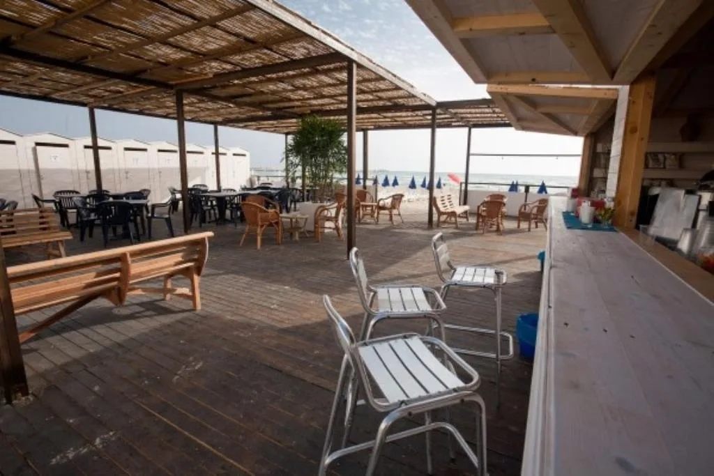 Bar sulla spiaggia con pergolato in legno e vista sul mare