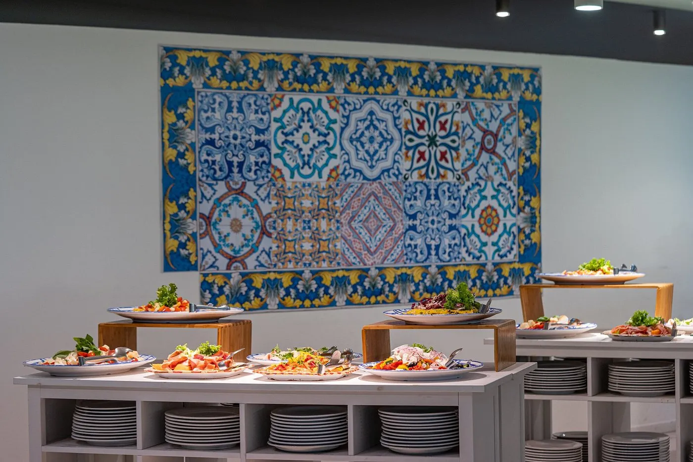 Buffet con piatti di antipasti e decorazione a maioliche siciliane