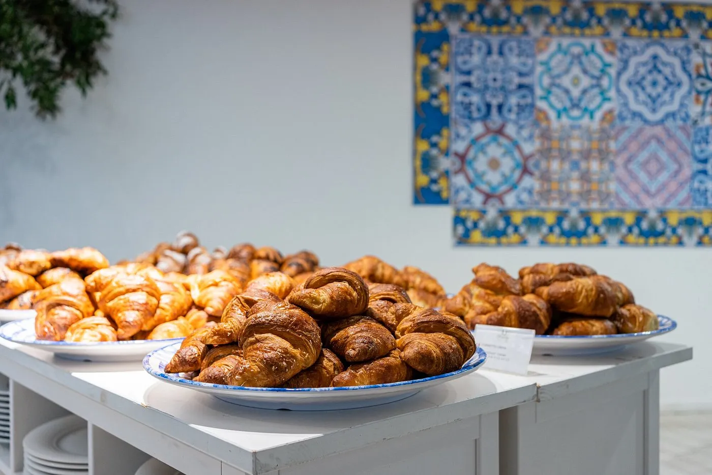 Buffet della colazione con cornetti e brioche su piatti decorati