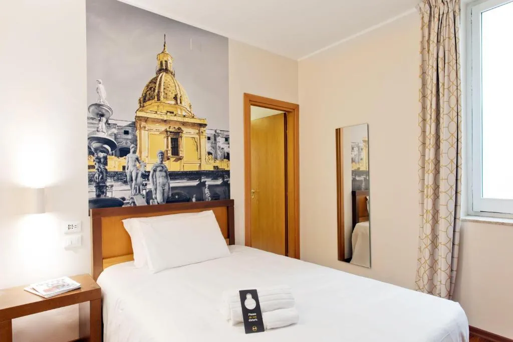 Camera singola con letto e decorazione murale della cupola di Palermo