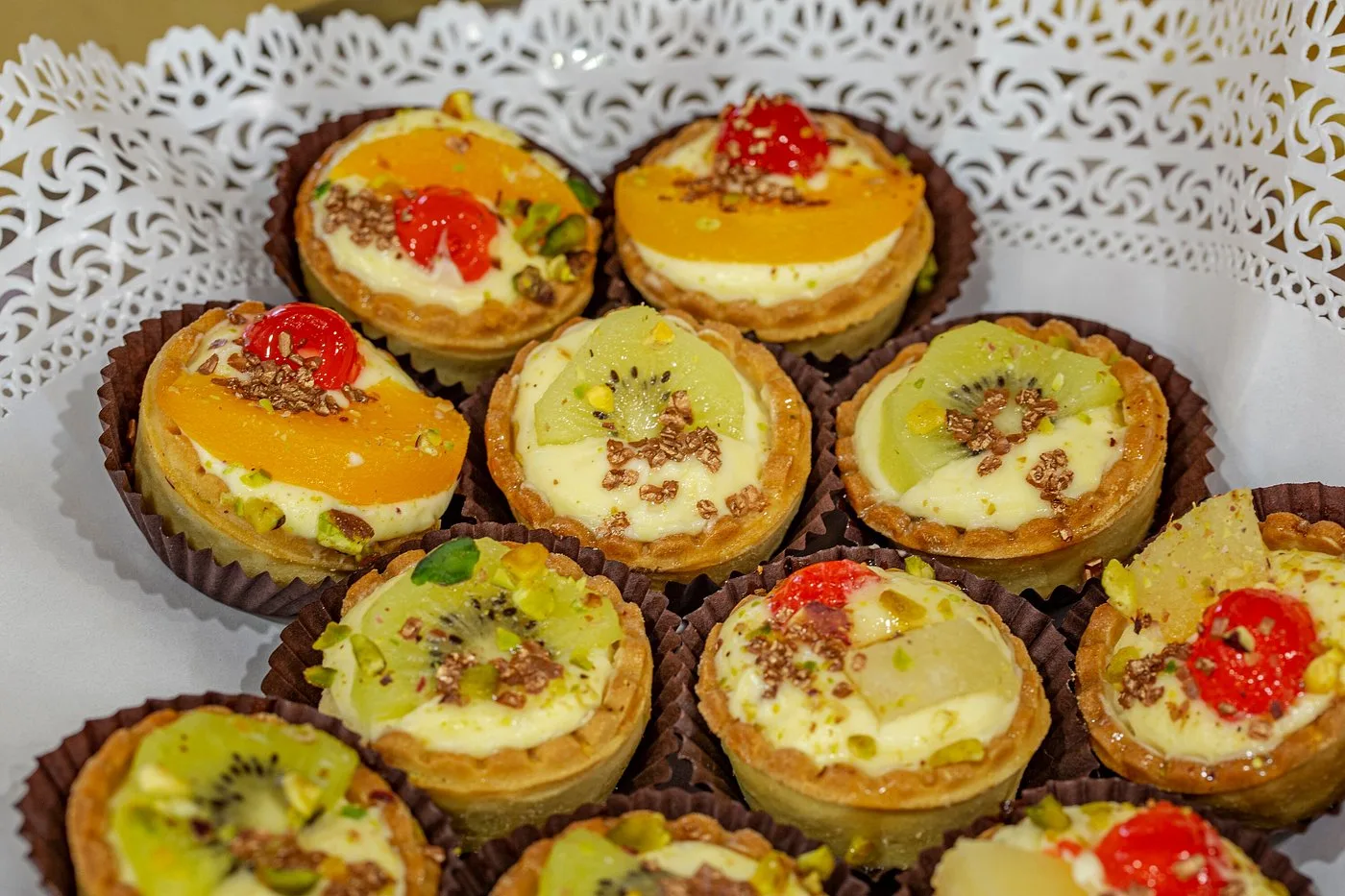 Vassoio di pasticcini con crema, frutta e granella di pistacchio
