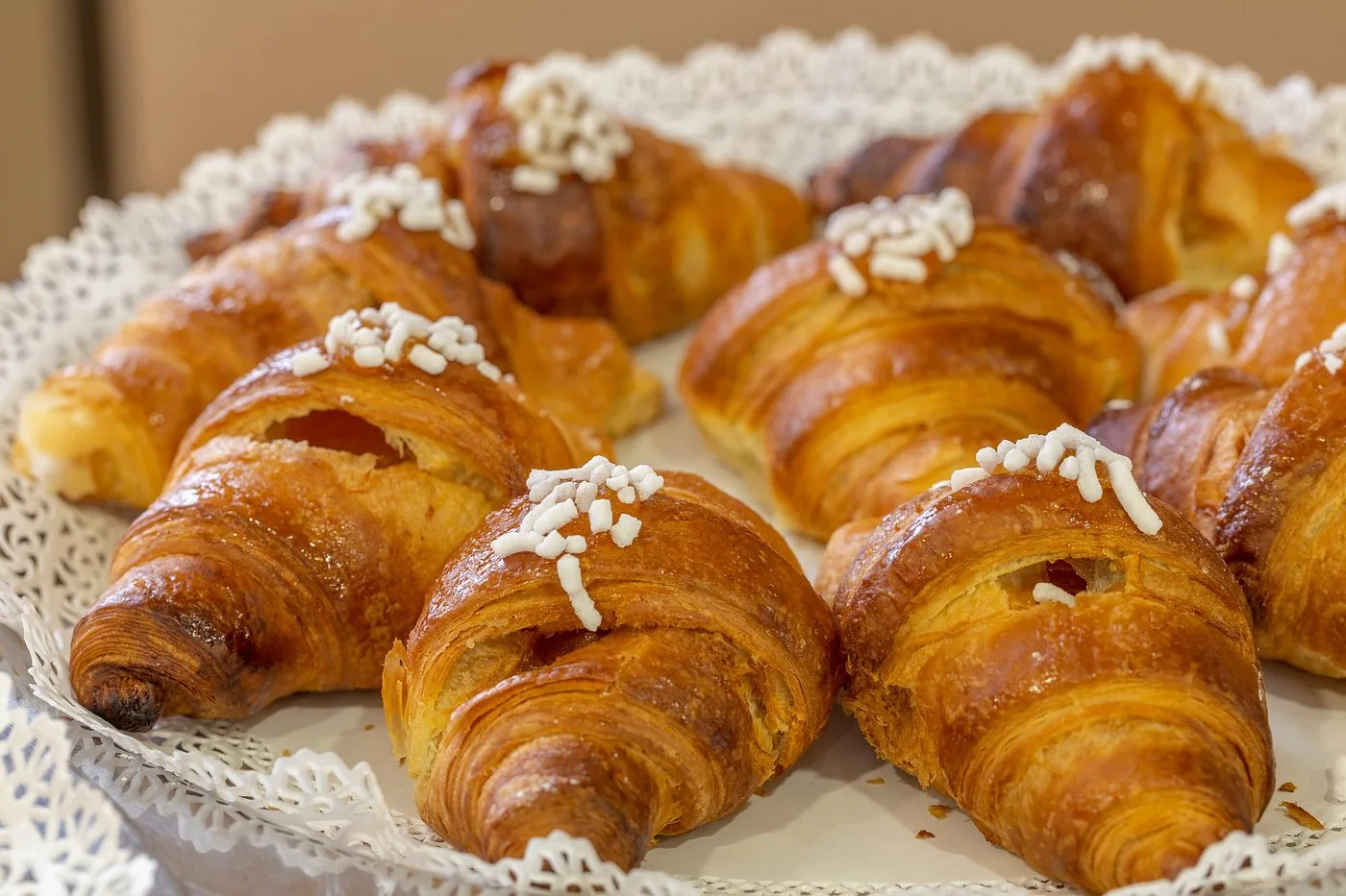 Vassoio di cornetti dorati con granella di zucchero per la colazione