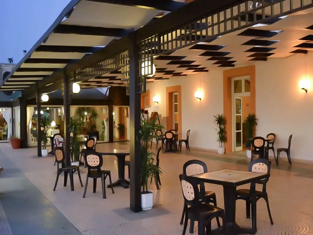 Terrazza coperta con tavoli e sedie illuminata al tramonto
