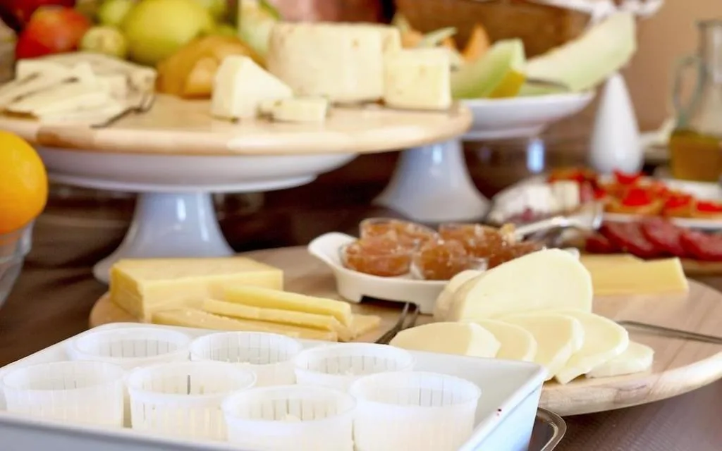 Buffet colazione con selezione di formaggi, frutta fresca e ricotta