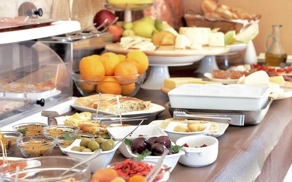 Ricco buffet colazione con formaggi, frutta, olive e prodotti tipici