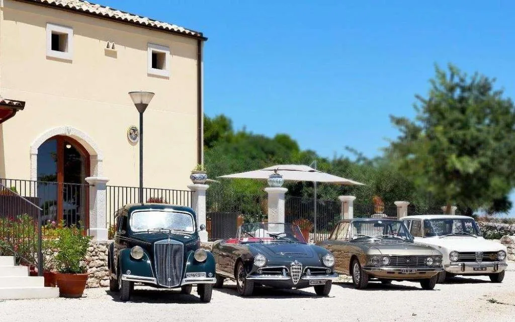 Auto d'epoca parcheggiate davanti all'edificio in pietra del resort
