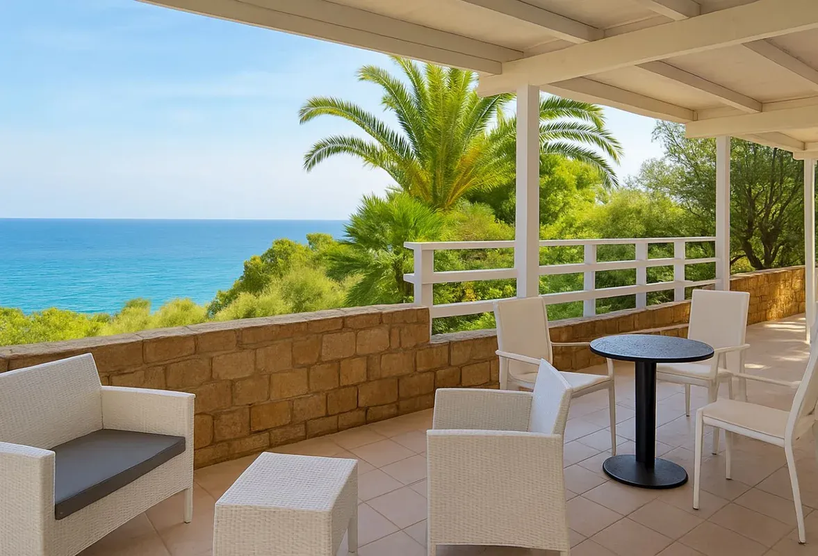 Terrazza con poltrone in rattan bianco, tavolino e vista panoramica sul mare