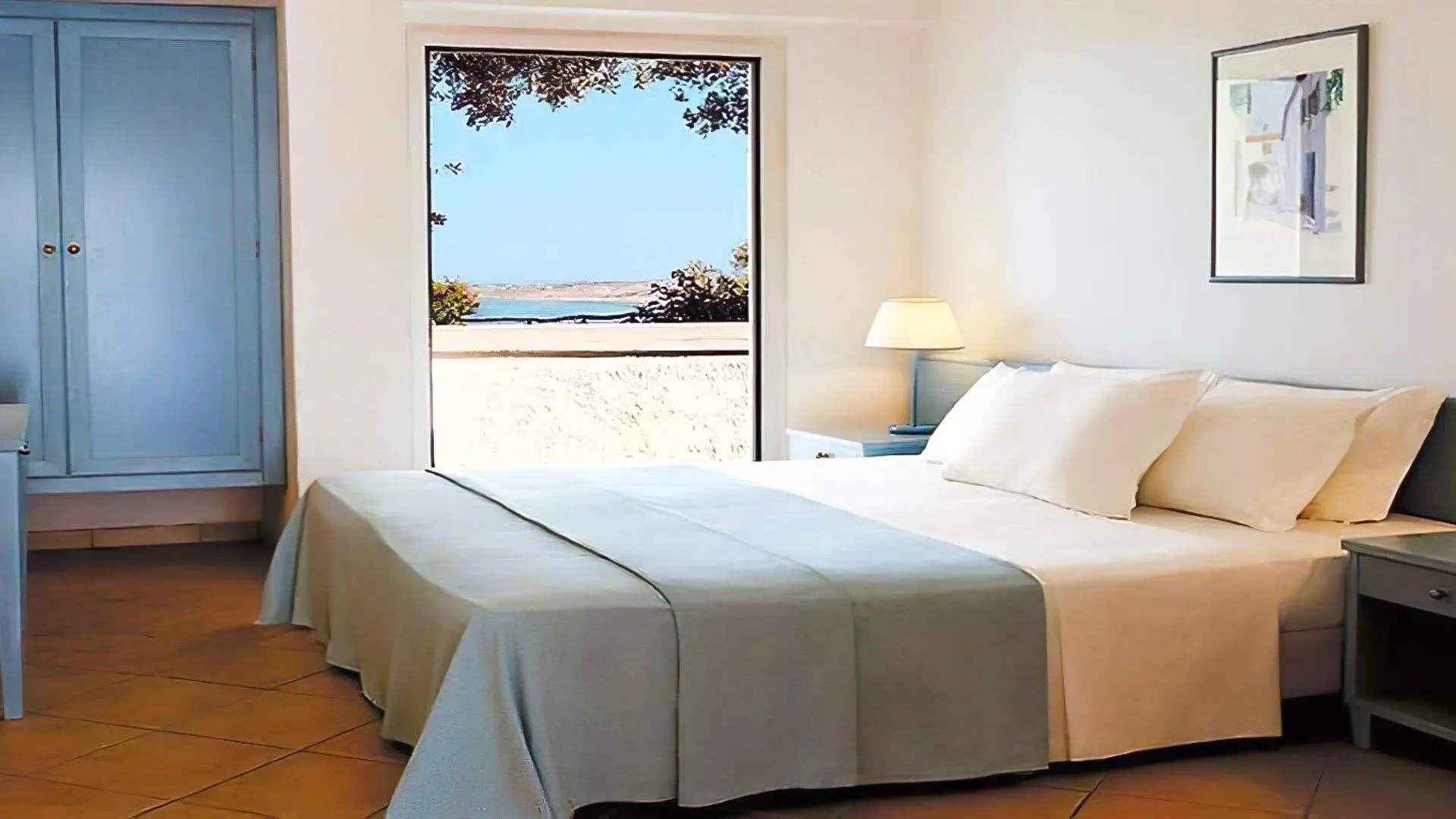 Camera luminosa con letto matrimoniale e ampia finestra con vista sulla spiaggia