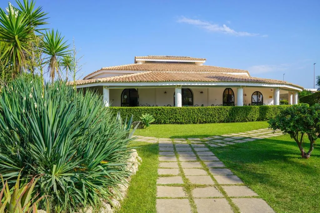 Edificio del ristorante con portico e giardino curato all'esterno