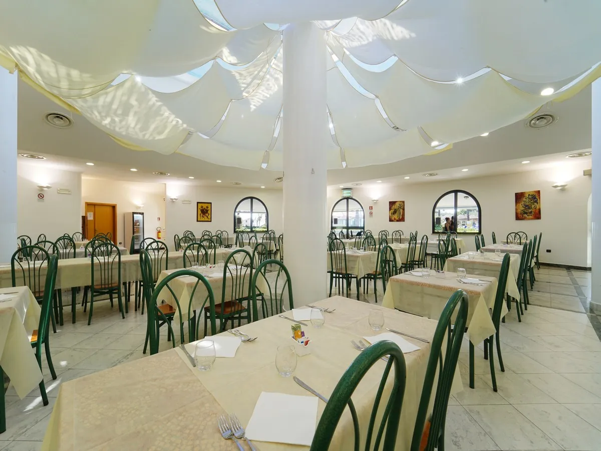 Sala ristorante interna con tavoli apparecchiati e soffitto decorato