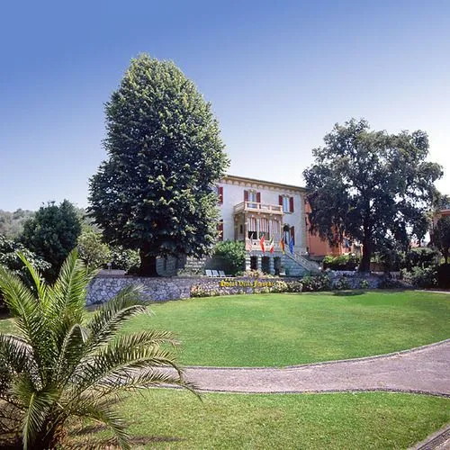 Villa immersa nel parco con ampio prato verde e alberi secolari