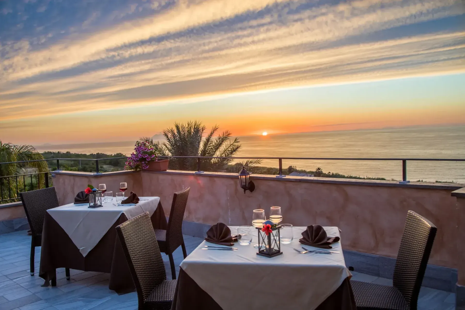 Tavoli del ristorante in terrazza con vista mare al tramonto