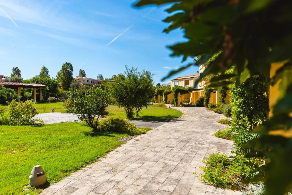 Percorso pedonale nel giardino verdeggiante del resort con alberi e vegetazione