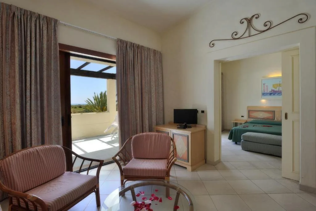 Zona living della suite con poltrone e camera da letto attigua