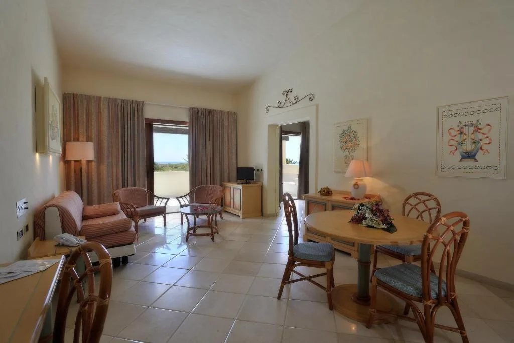 Soggiorno di una suite con divano, tavolo da pranzo e uscita sul terrazzo