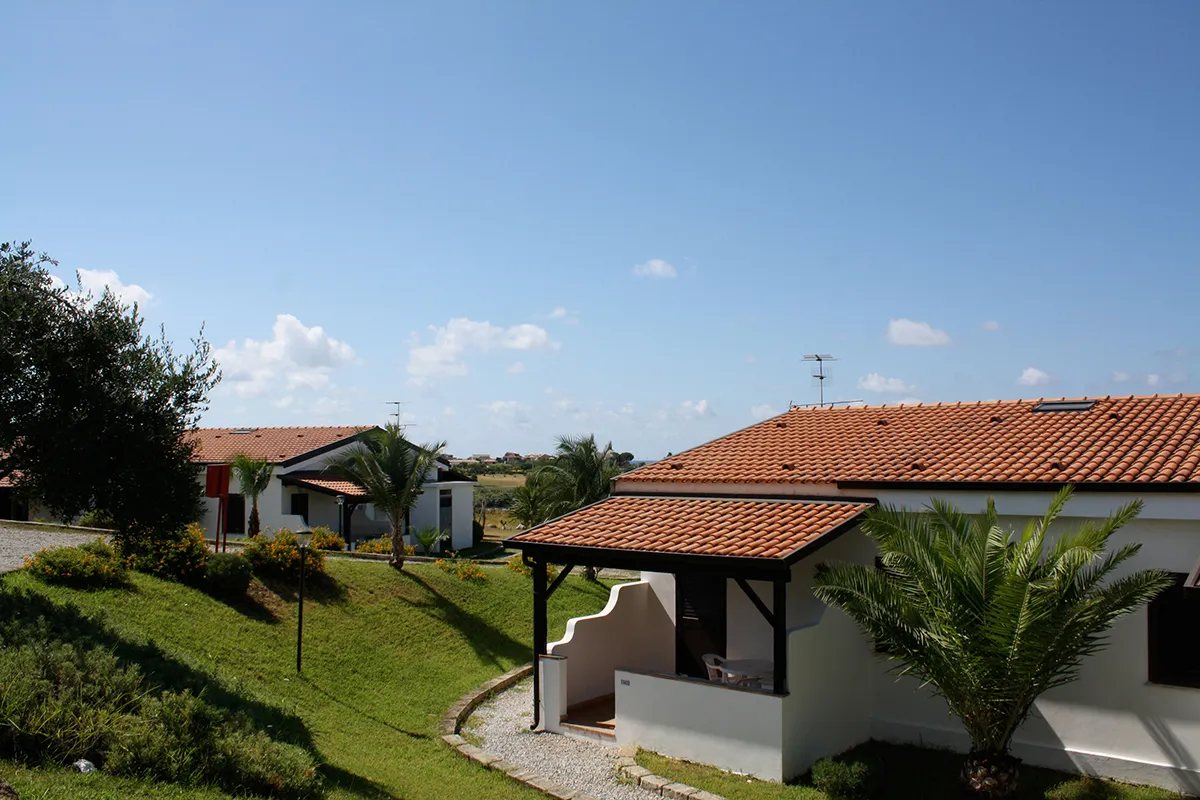 Bungalow del resort con tetto in tegole, veranda e giardino verde