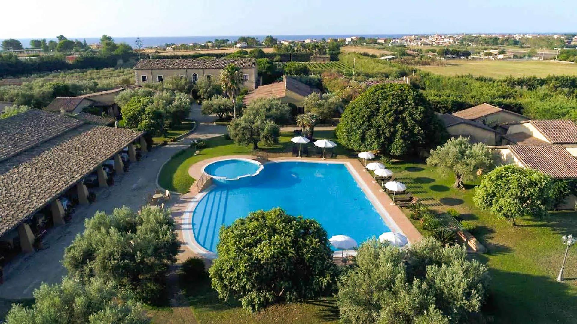 Veduta aerea della piscina con campagna, uliveti e mare sullo sfondo