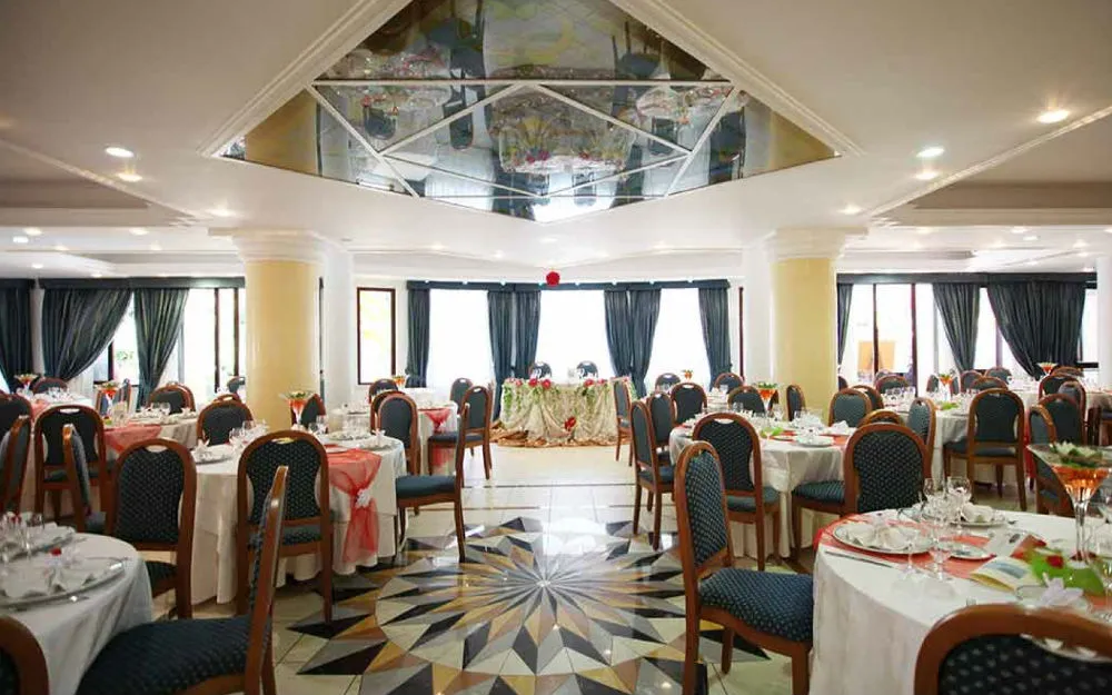 Sala ristorante elegante con tavoli apparecchiati e pavimento decorato