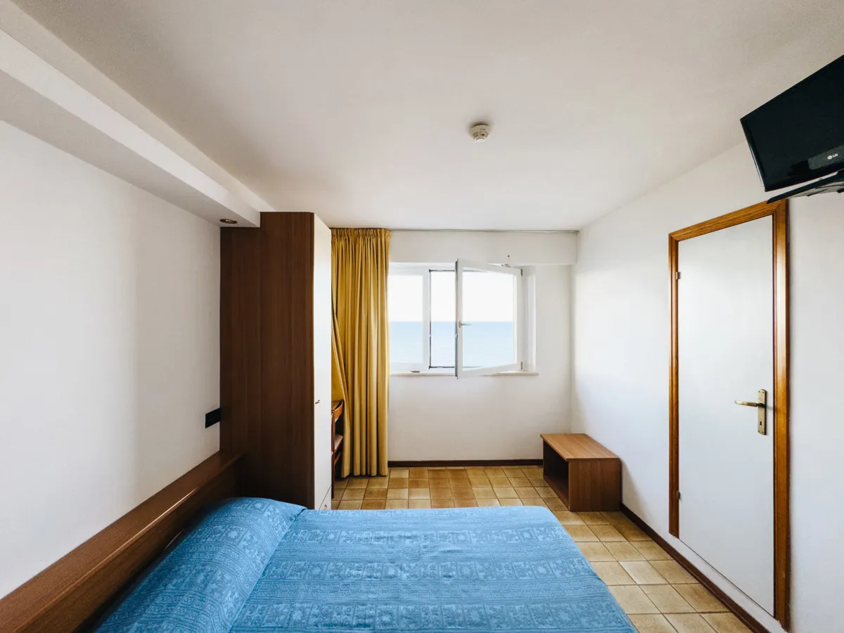 Camera con letto matrimoniale e finestra con vista mare