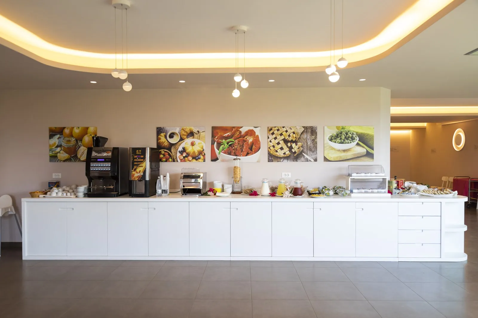 Buffet della colazione con macchine del caffè, succhi e dolci nella sala interna