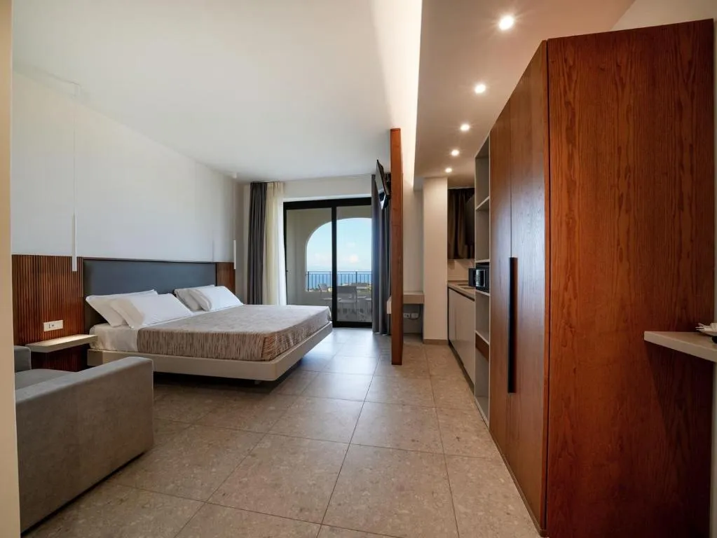 Camera con letto matrimoniale, angolo cottura e balcone con vista mare