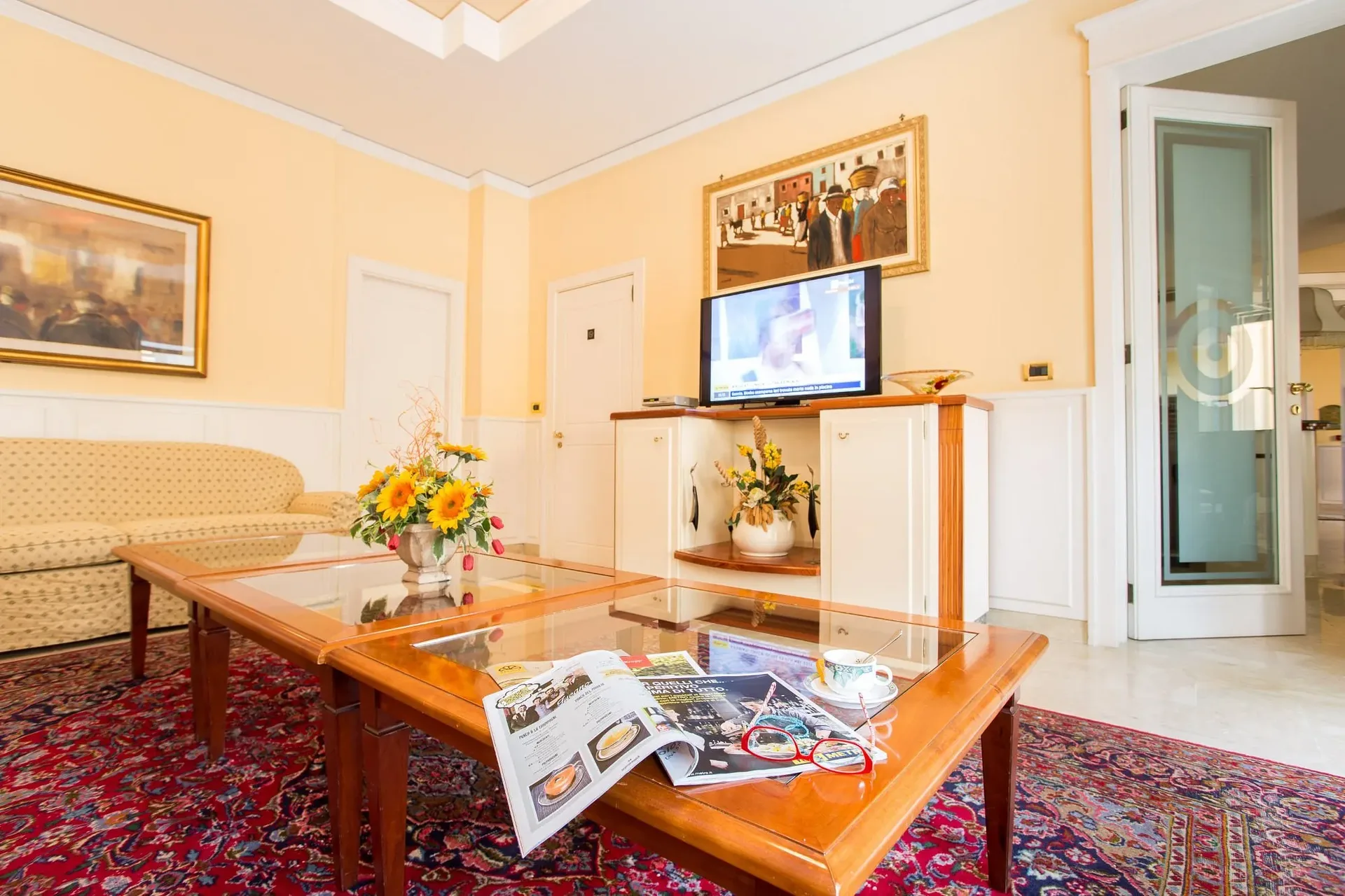 Sala soggiorno con divani, tavolini in legno e televisore