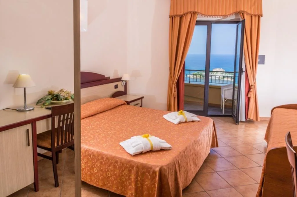 Camera con letto matrimoniale arancione e balcone con vista mare panoramica