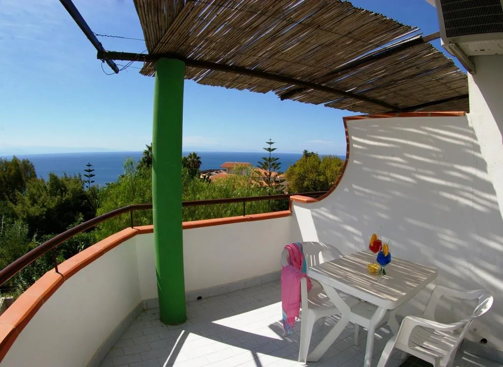 Terrazza privata con copertura in canne, tavolo e vista sul mare