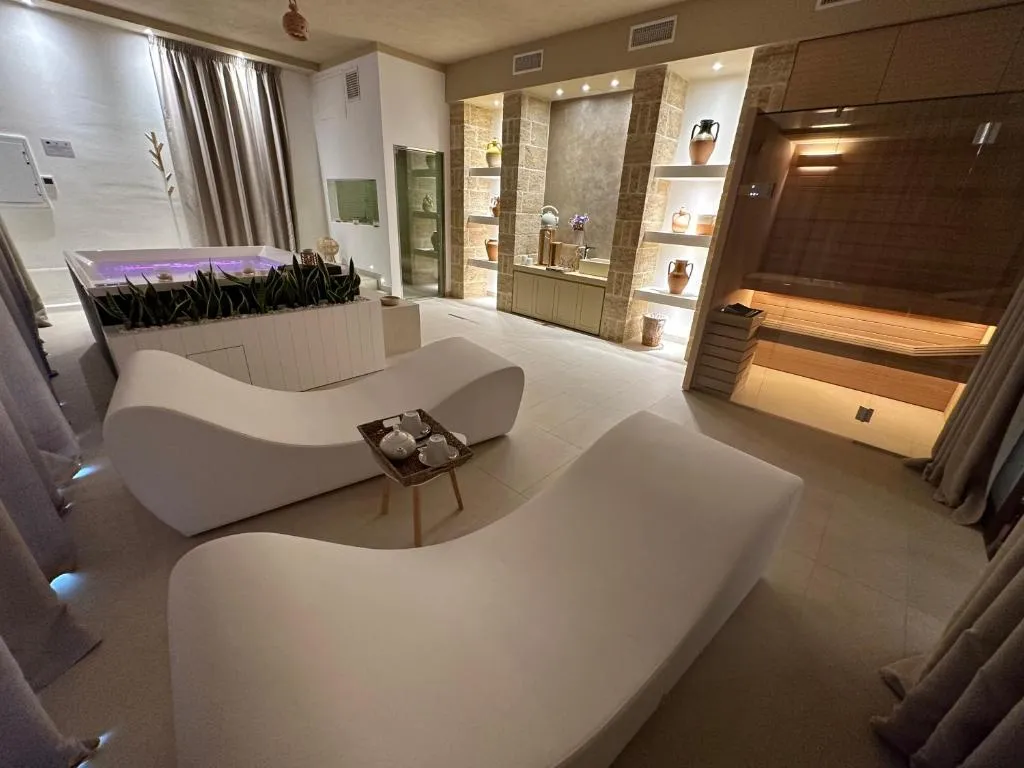 Centro benessere con lettini relax bianchi, vasca idromassaggio e sauna
