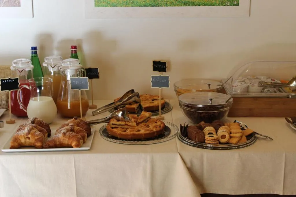 Buffet colazione con croissant, crostate, biscotti e succhi di frutta