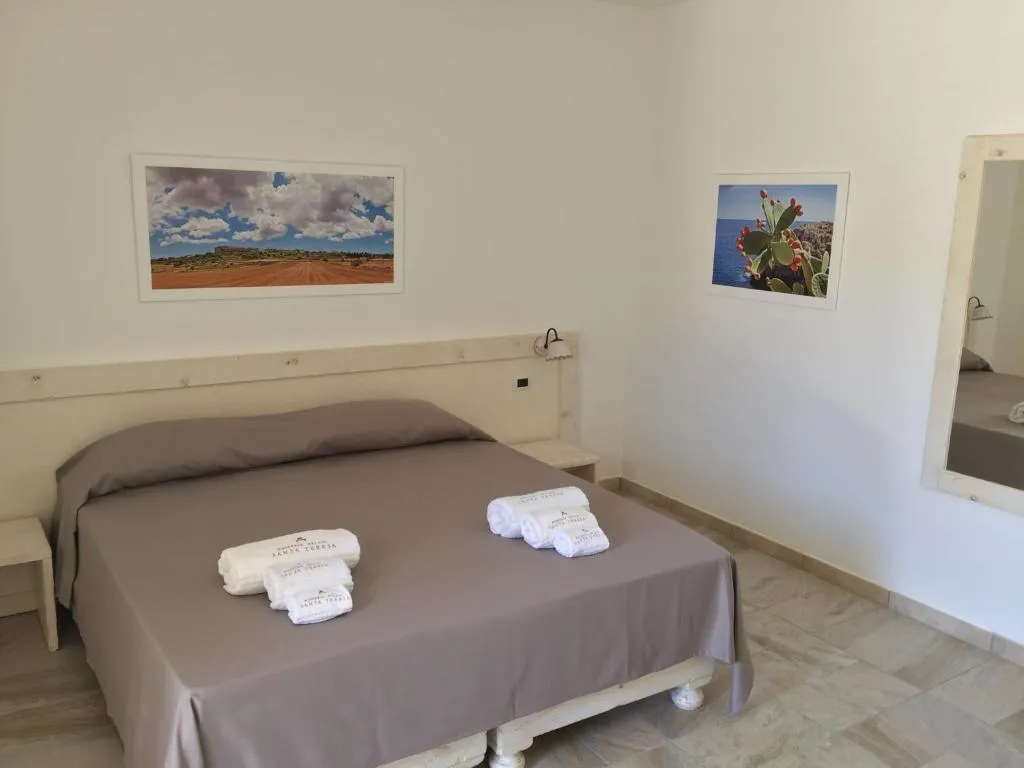 Camera da letto matrimoniale con pareti bianche e quadri paesaggistici