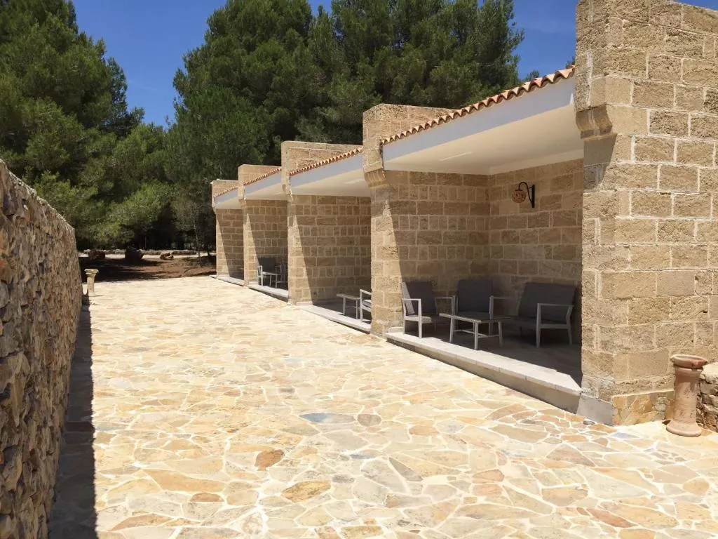 Portico esterno in pietra con poltrone e pavimentazione in pietra naturale