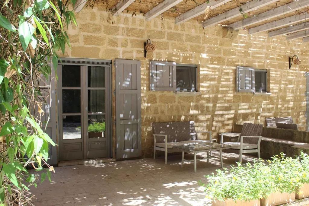 Veranda esterna ombreggiata con poltrone e tavolo davanti a porta-finestra