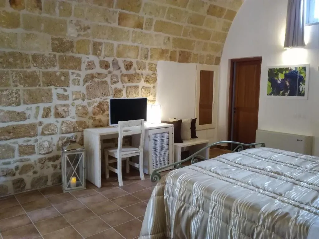 Camera con volta a botte in pietra, letto e angolo scrivania